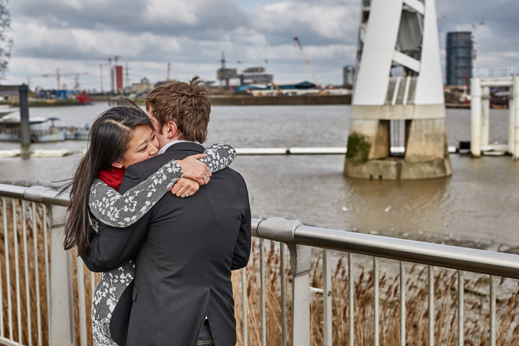 Couple hugging beside the River Thames after the proposal