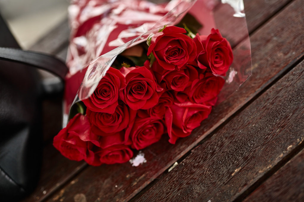 Bouquet of red roses on a wooden bench