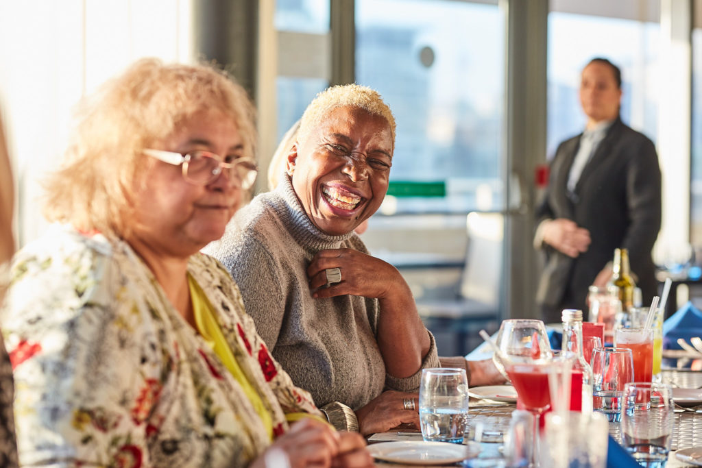Two guests smiling together at the birthday table