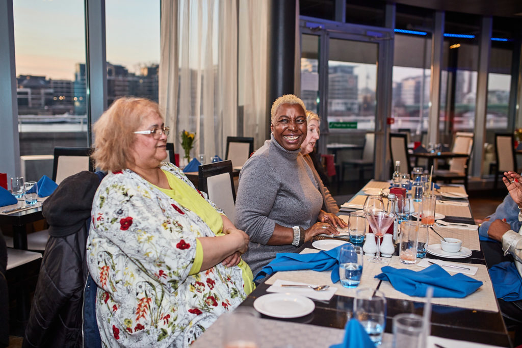 Guests smiling at the table as evening falls