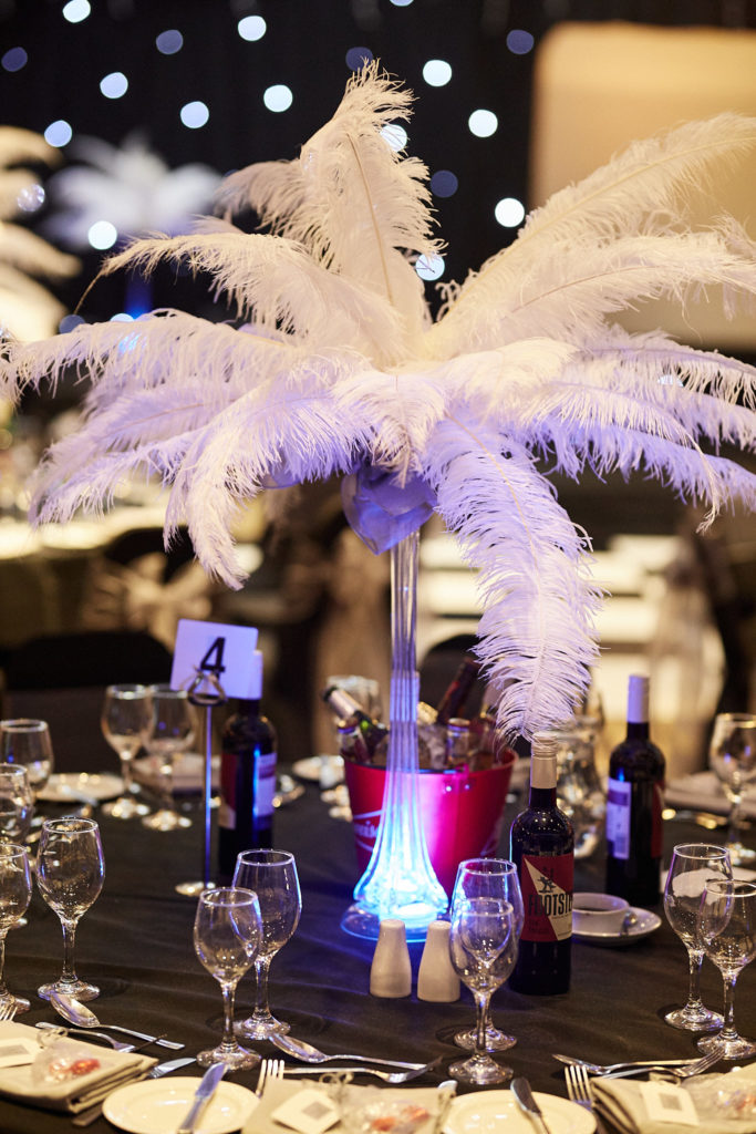 White ostrich feather centrepiece on a table set for an awards evening at the Elstree Holiday Inn