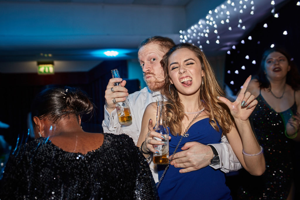 Guests laughing together with drinks under a starlight ceiling