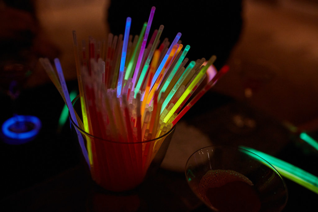 Glass of neon glow sticks on a table