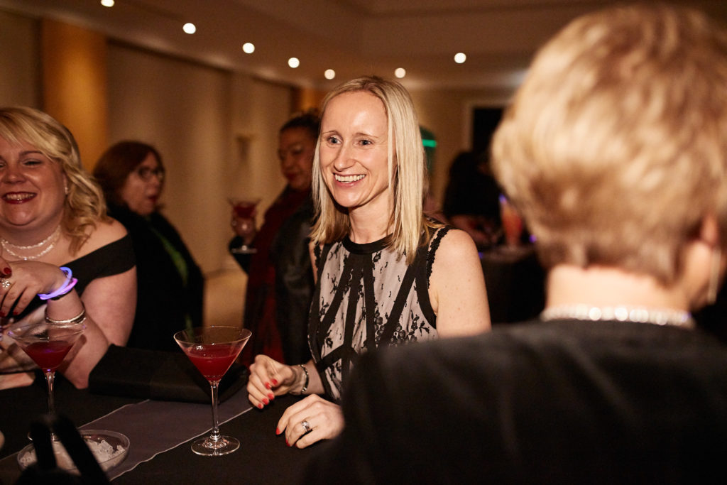 Guest smiling with a cocktail at the drinks reception