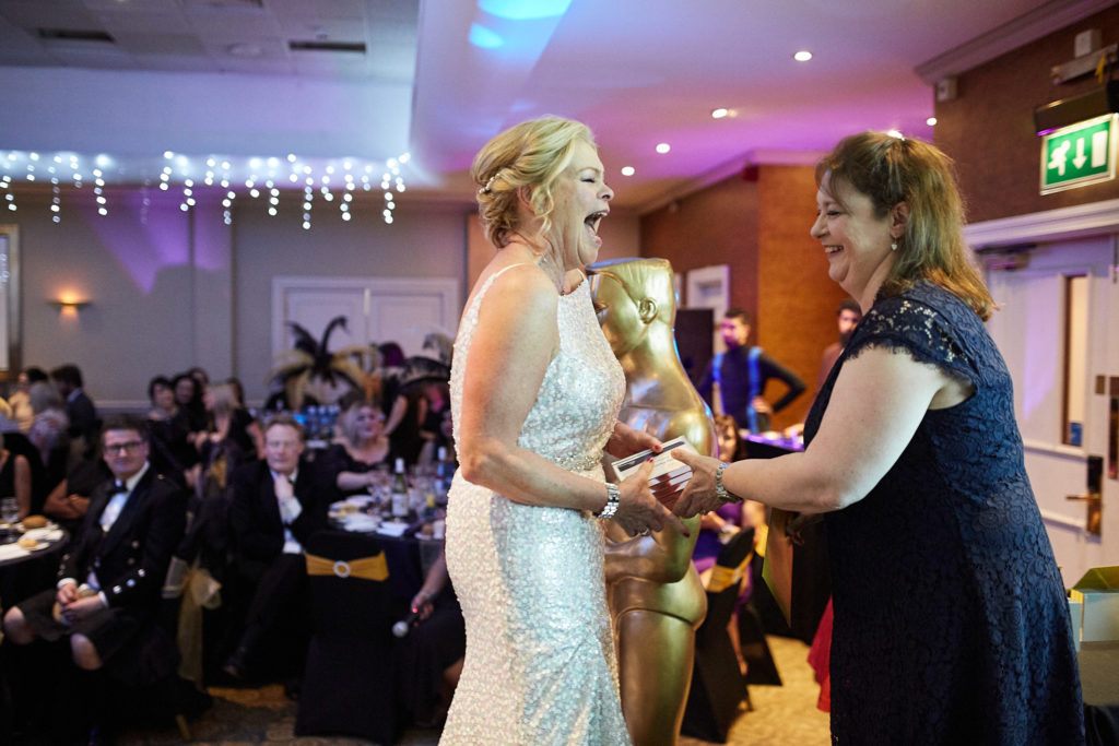 Award winner being congratulated as she collects her award
