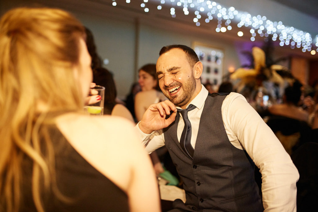 Guest in a waistcoat laughing with a colleague