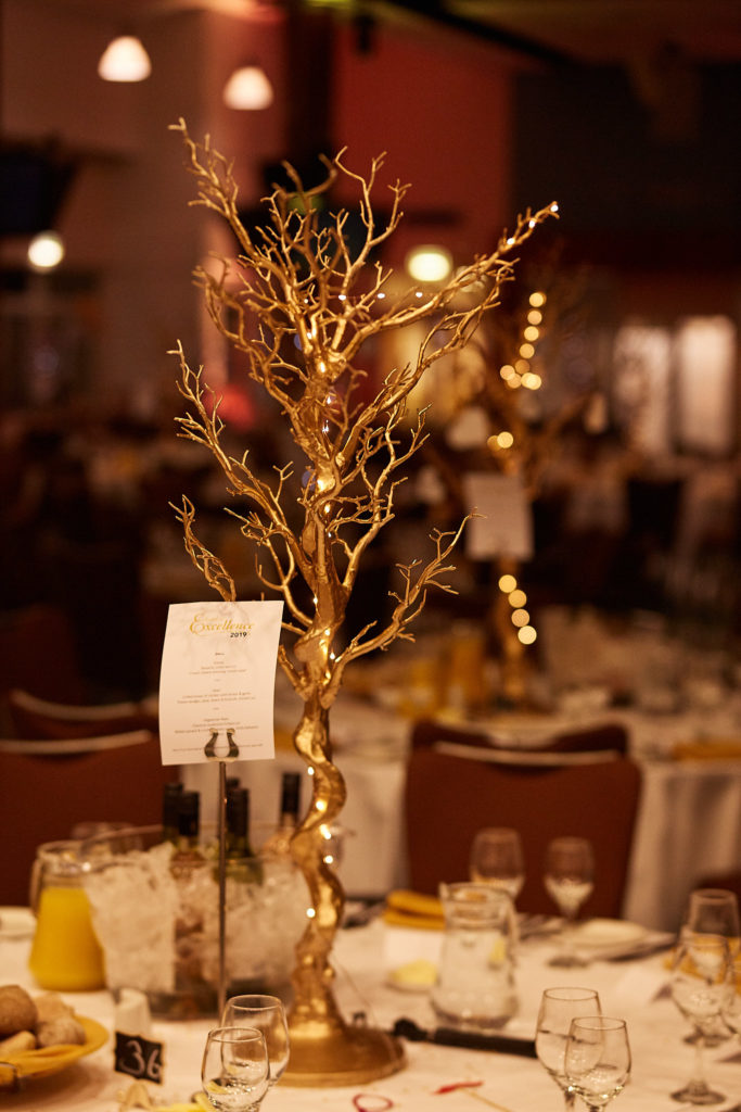 Gold tree centrepiece on a table set for an awards evening at Epsom Racecourse