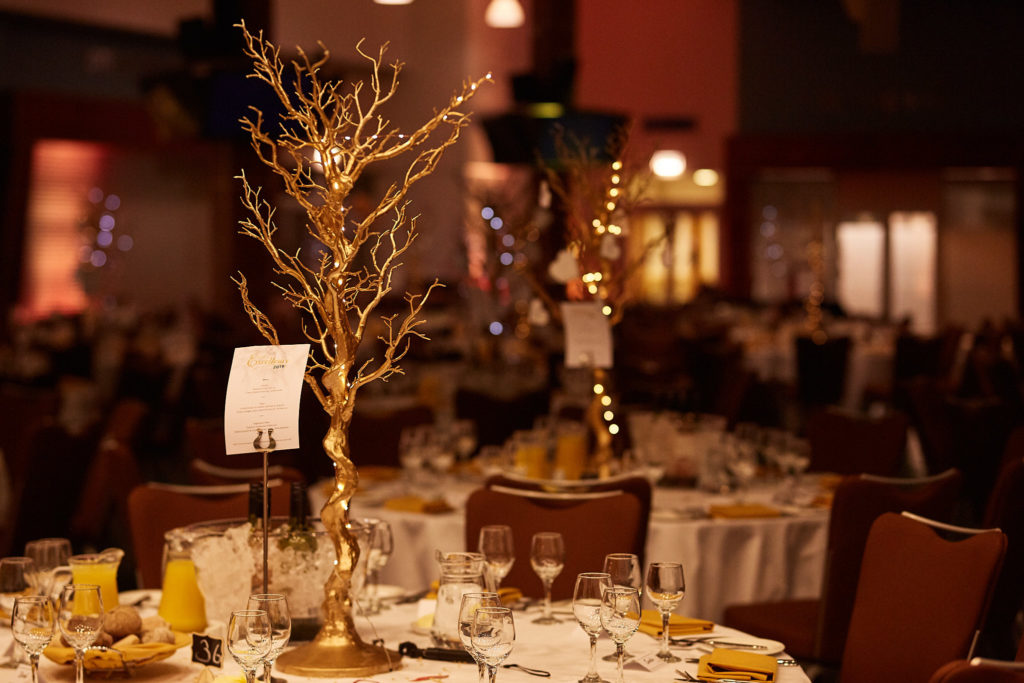 Awards dinner tables with gold tree centrepieces at Epsom Racecourse, Surrey