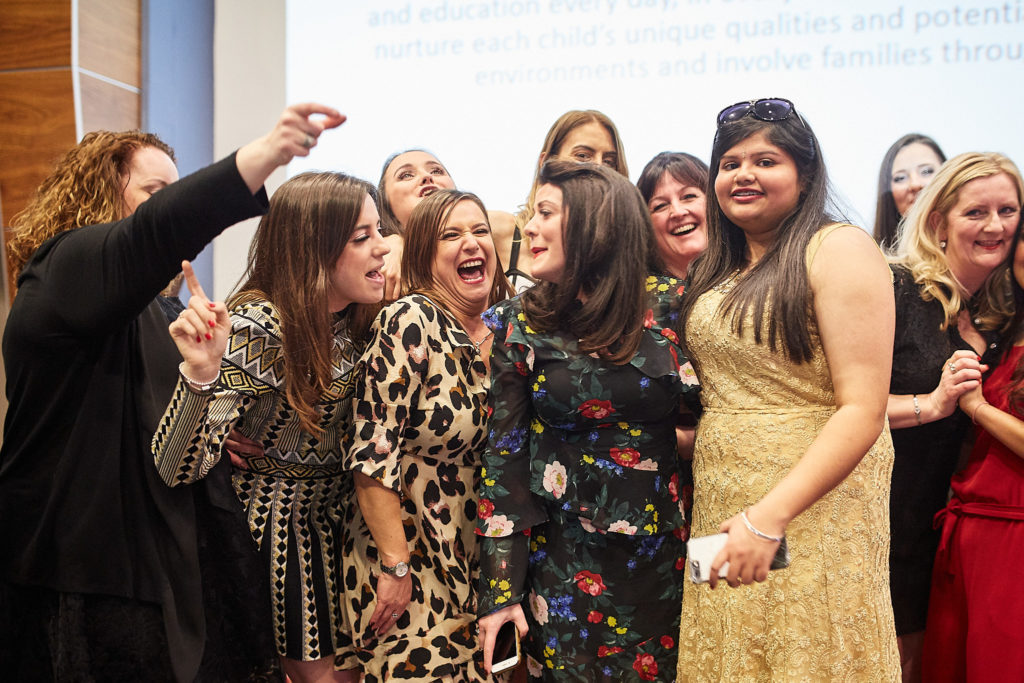 Group of guests laughing as they pose for a photo