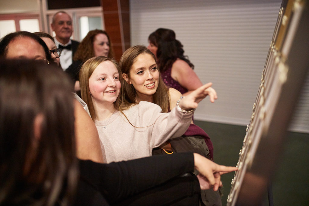Guests pointing out their names on the table plan