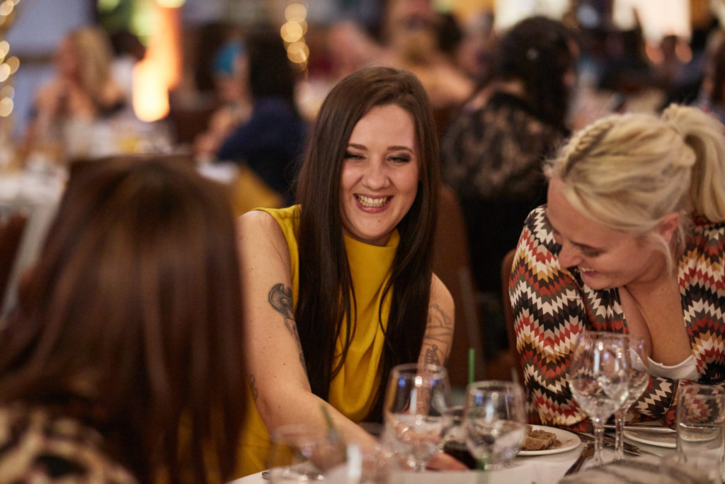 Guests laughing together at the awards dinner