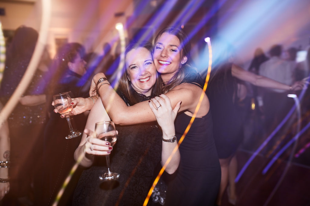 Two guests hugging on the dance floor among trails of light