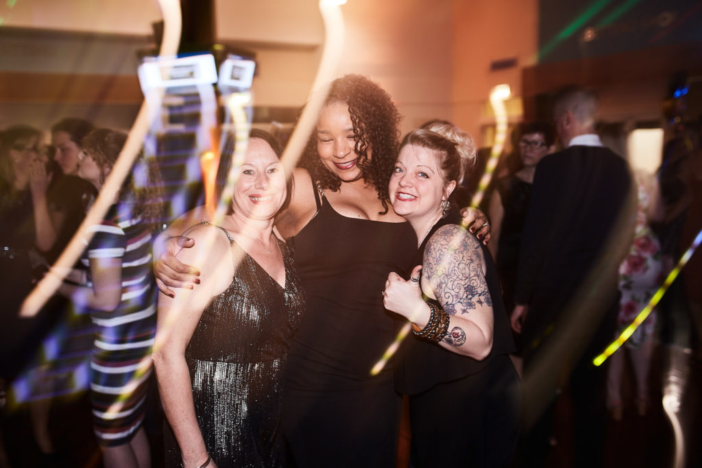 Three guests posing together on the dance floor