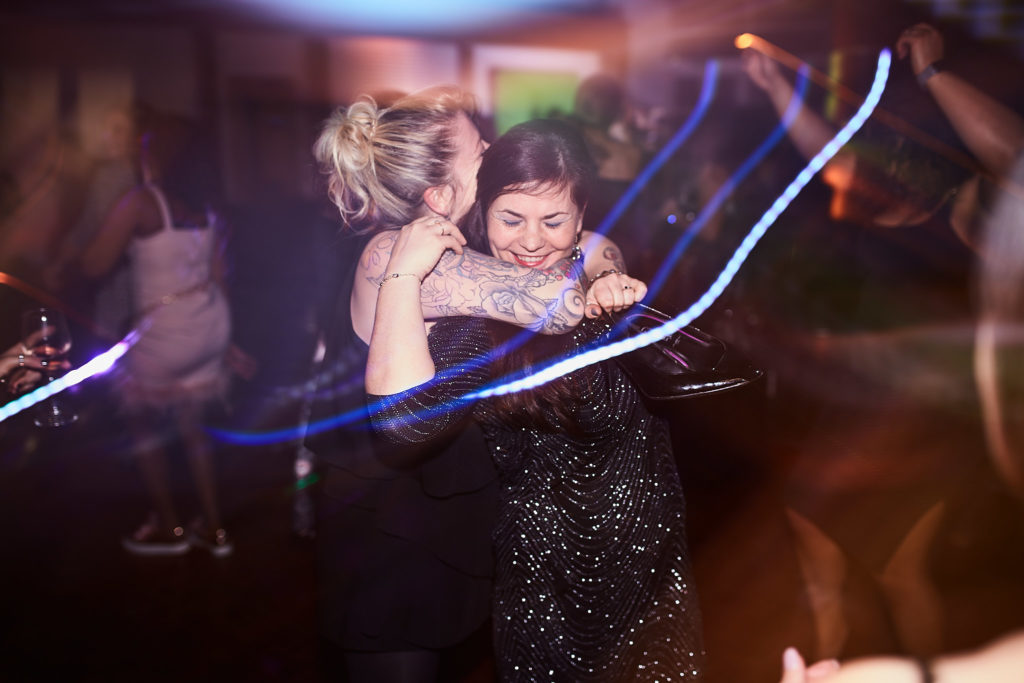 Two guests hugging on the dance floor under blue light trails