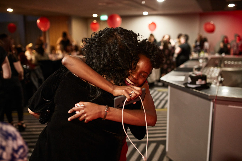 Two guests hugging after an award is announced