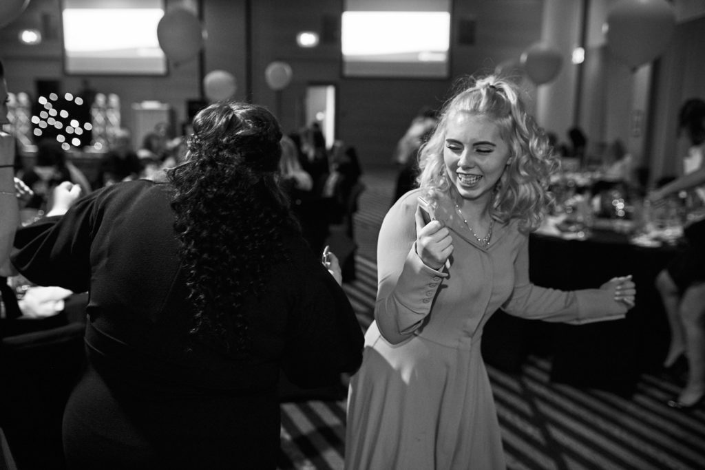 Black and white photo of a guest pointing as she dances