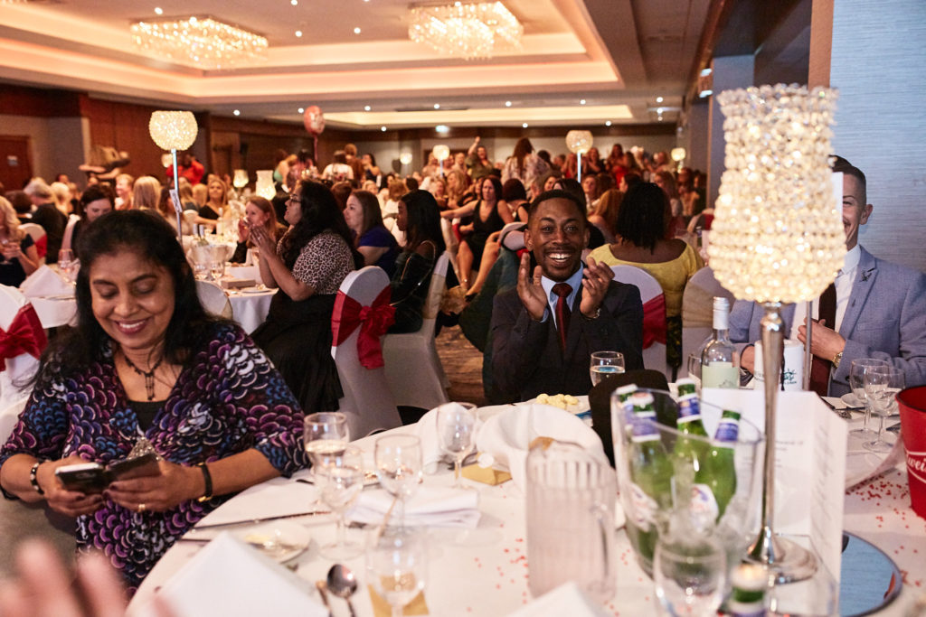 Guest smiling at her table in the banqueting hall