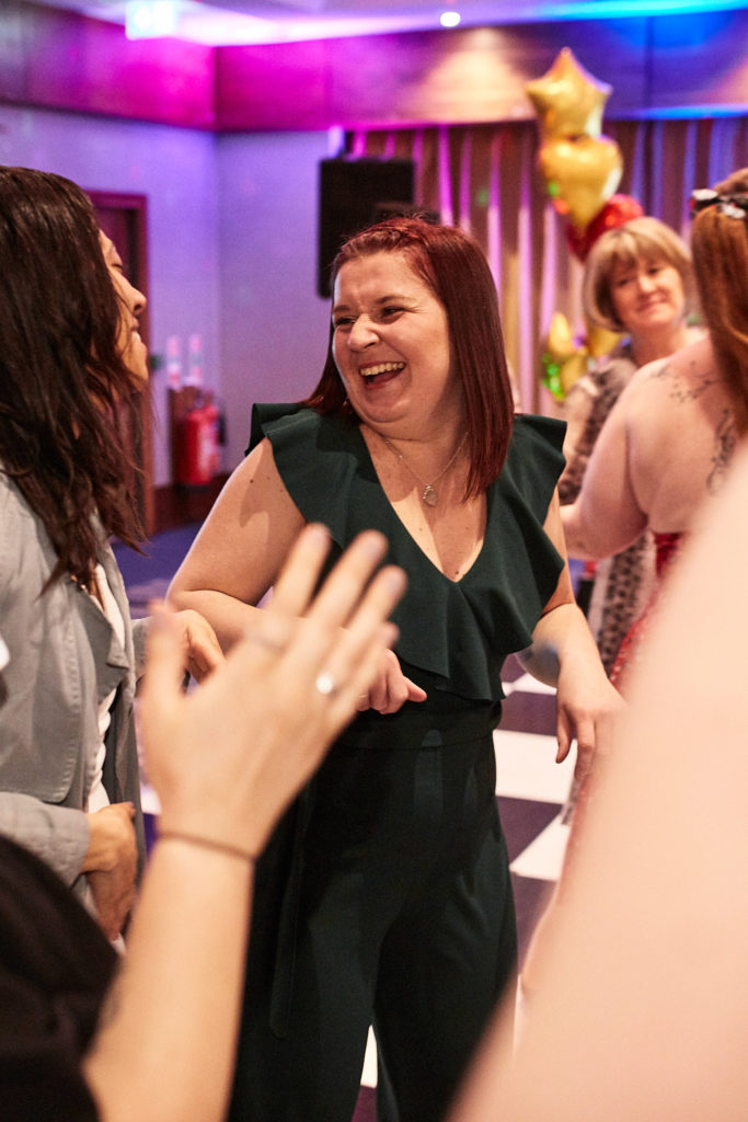 Guest laughing on the dance floor as others clap