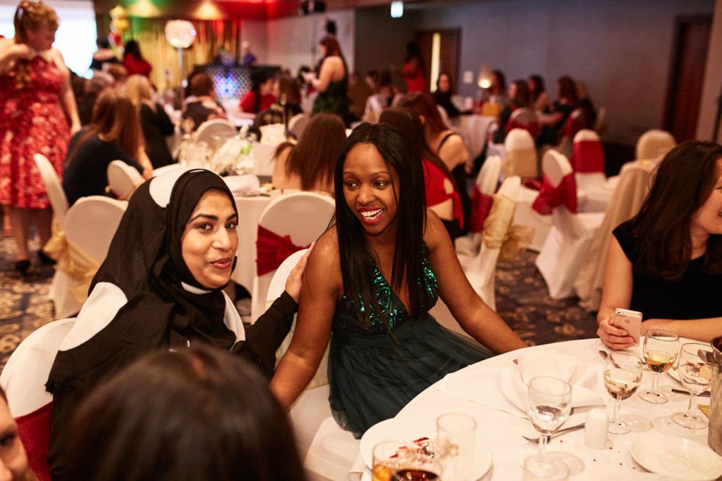 Two guests smiling at their table in the banqueting hall at the Wembley Holiday Inn, London