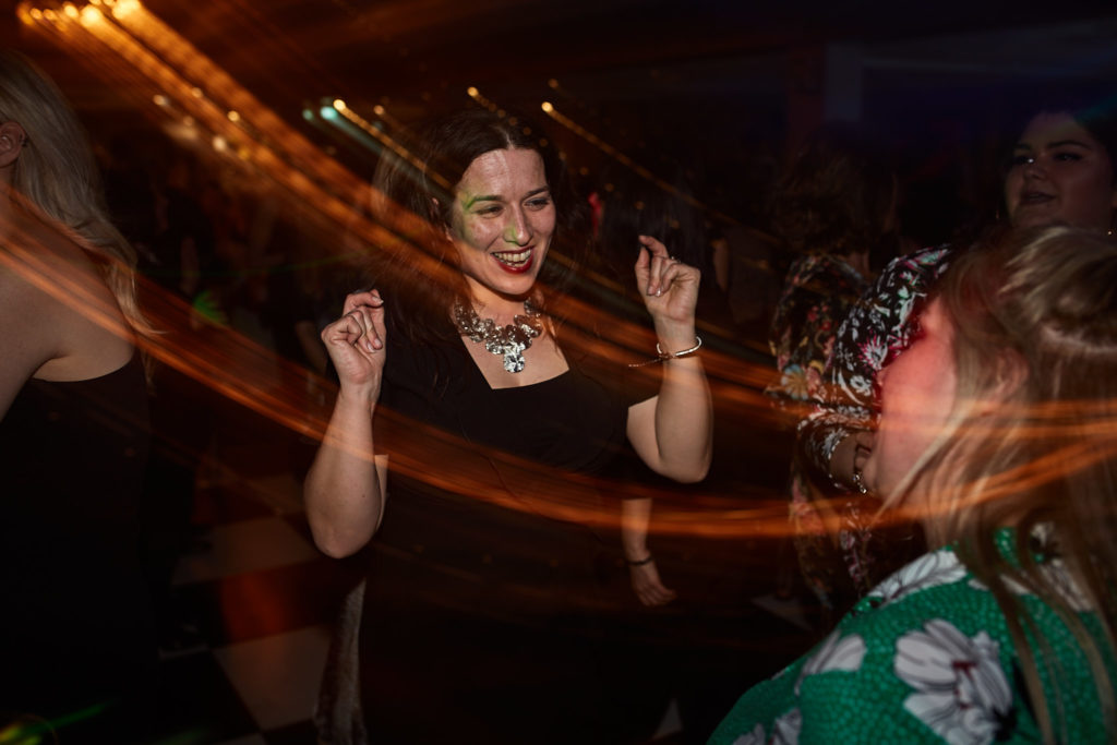 Guest dancing among trails of orange light