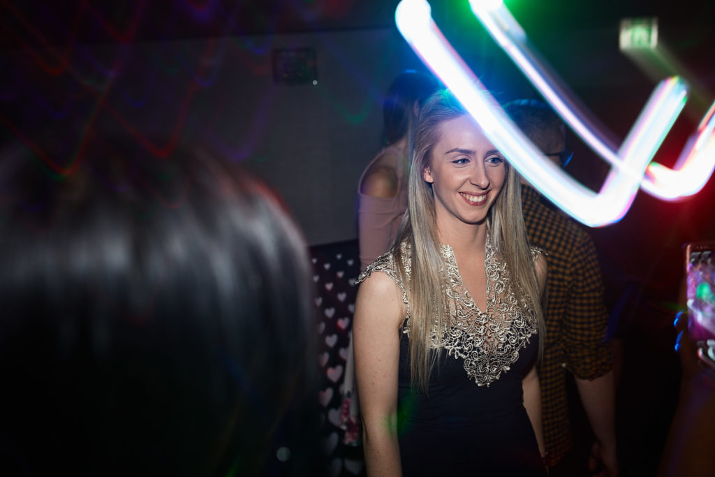 Guest smiling on the dance floor under a swirl of light