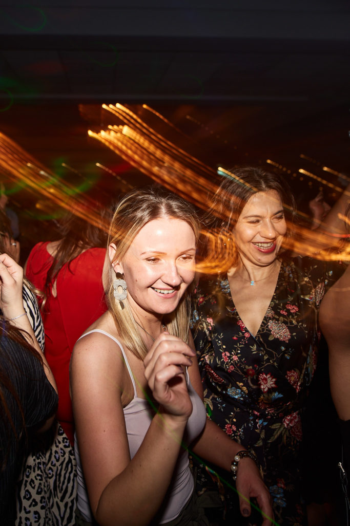 Two guests smiling as they dance together
