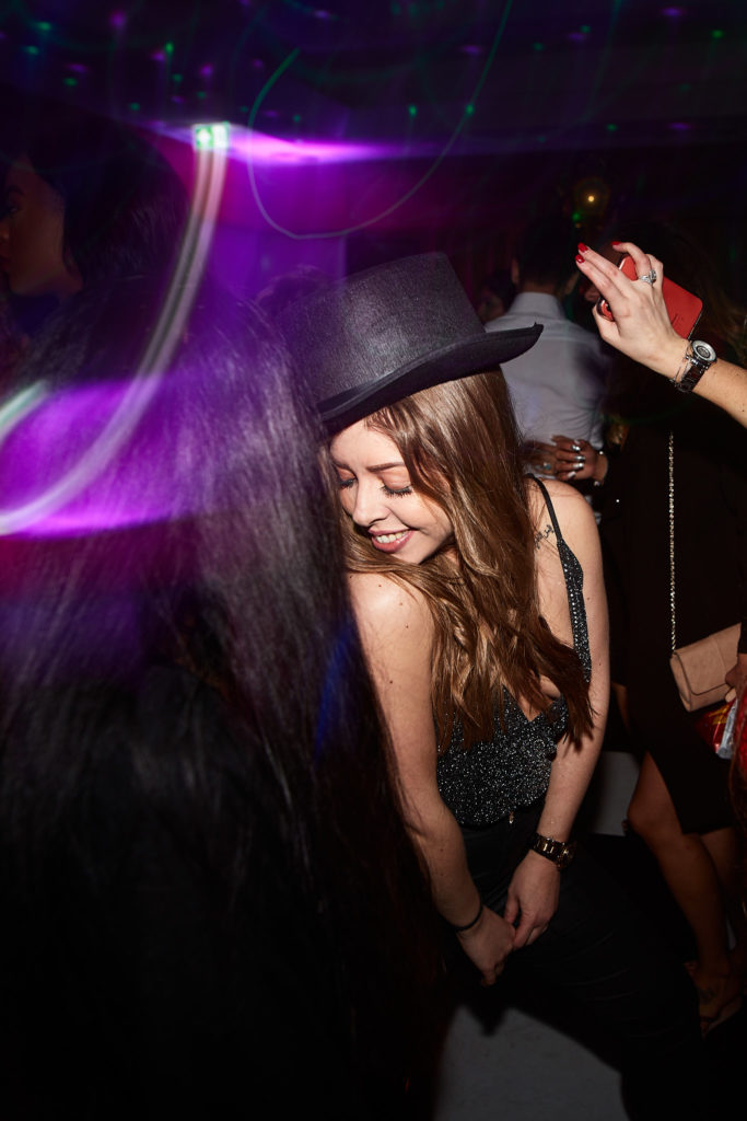 Guest in a top hat laughing as she dances