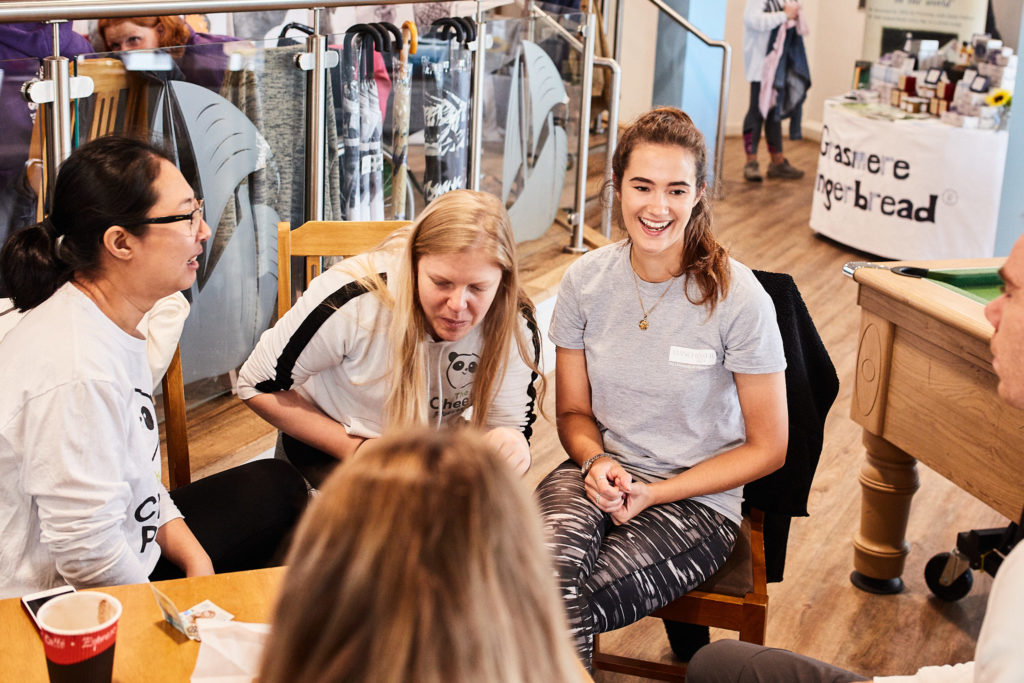 Volunteers smiling at a table inside the clubhouse