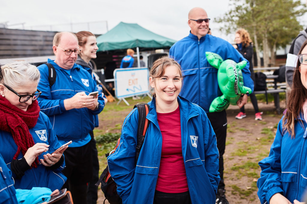 Supporters in blue jackets smiling at the charity event