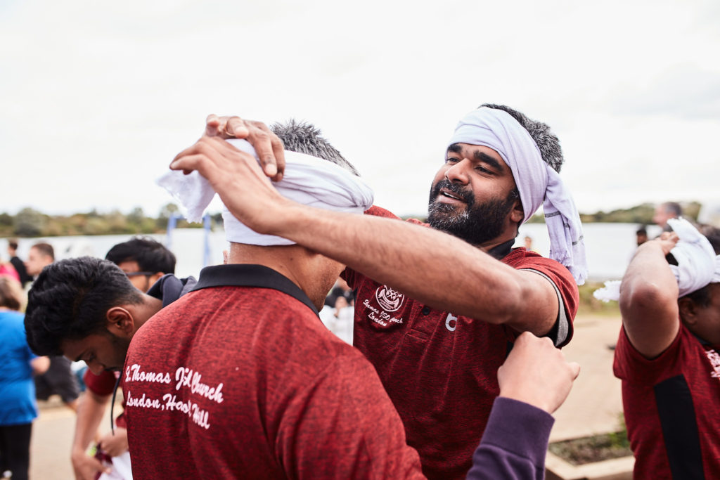 Team in maroon shirts tying on white headbands before their race