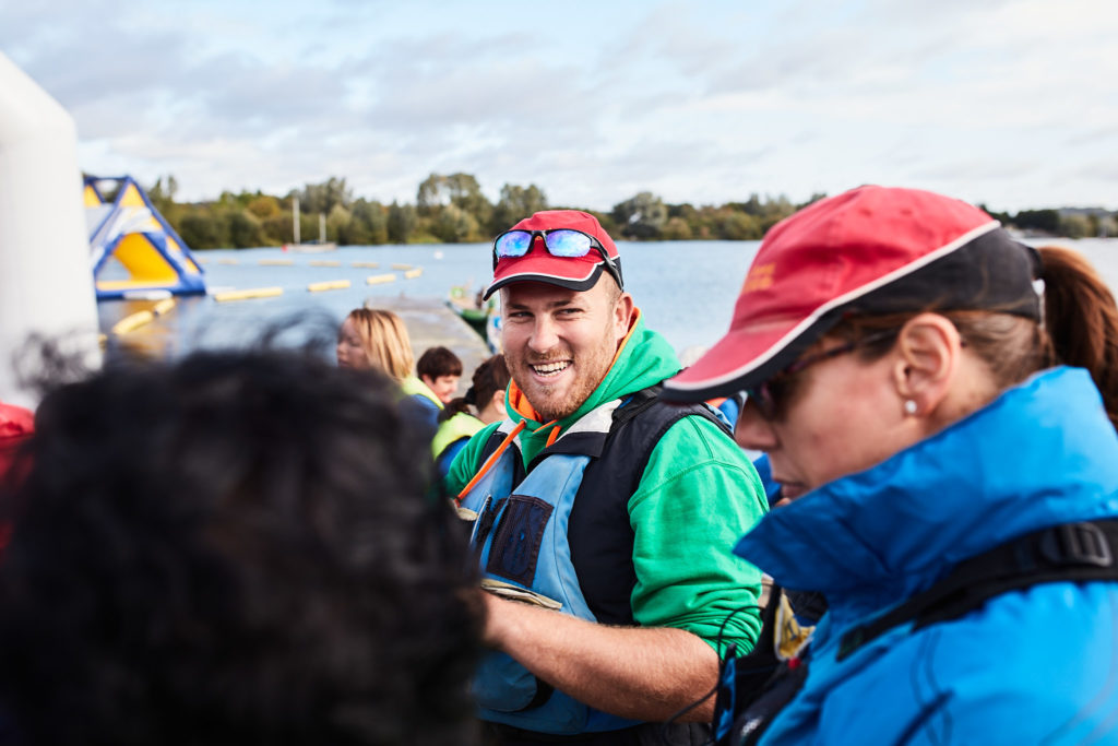 Paddler in a red cap smiling in a buoyancy aid