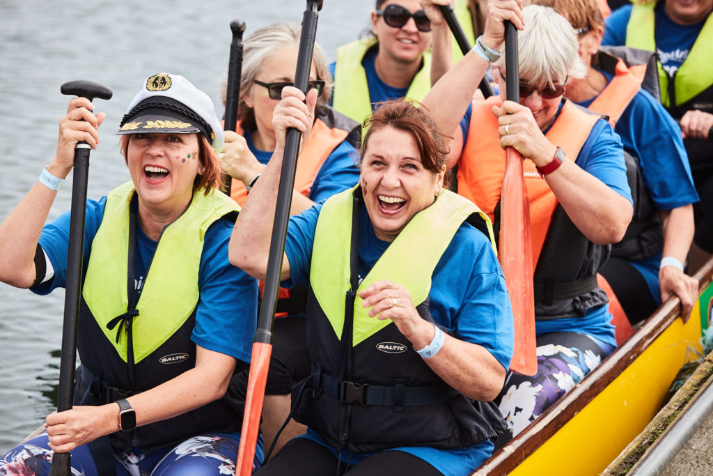 Team laughing in their dragon boat before the race