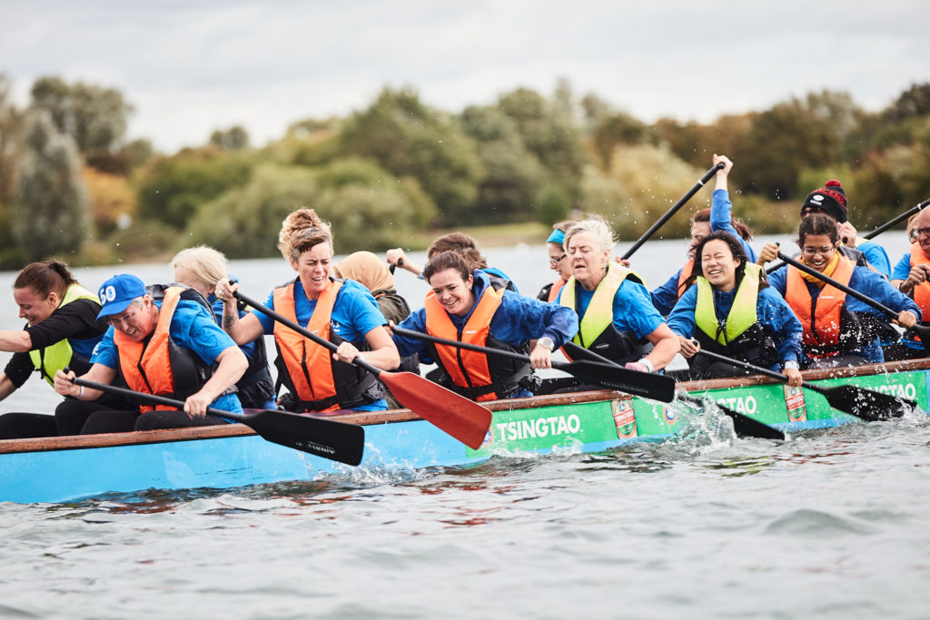 Dragon boat crew paddling hard during a race at the charity dragon boat festival