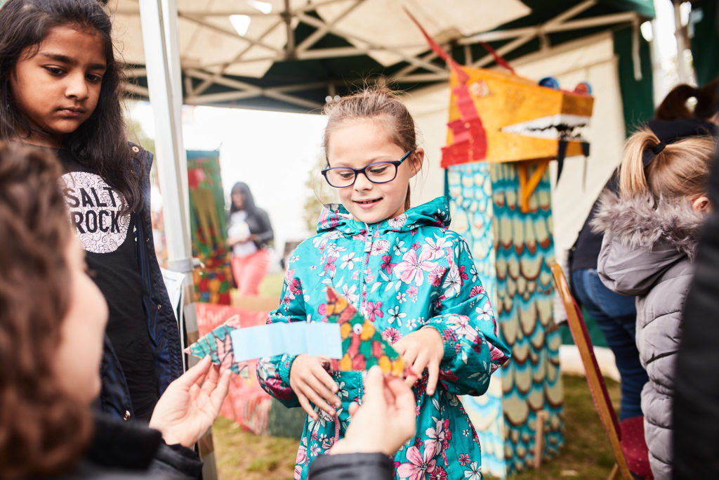 Girl in glasses smiling at a craft stall