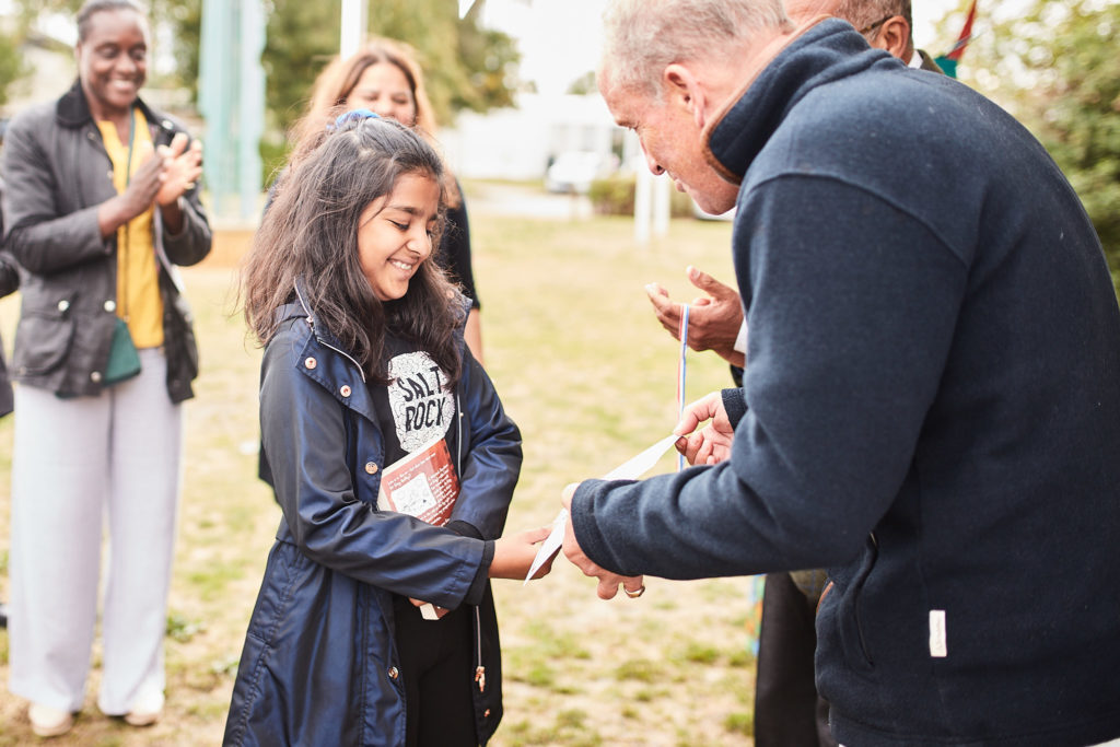 Girl smiling as she is handed a prize