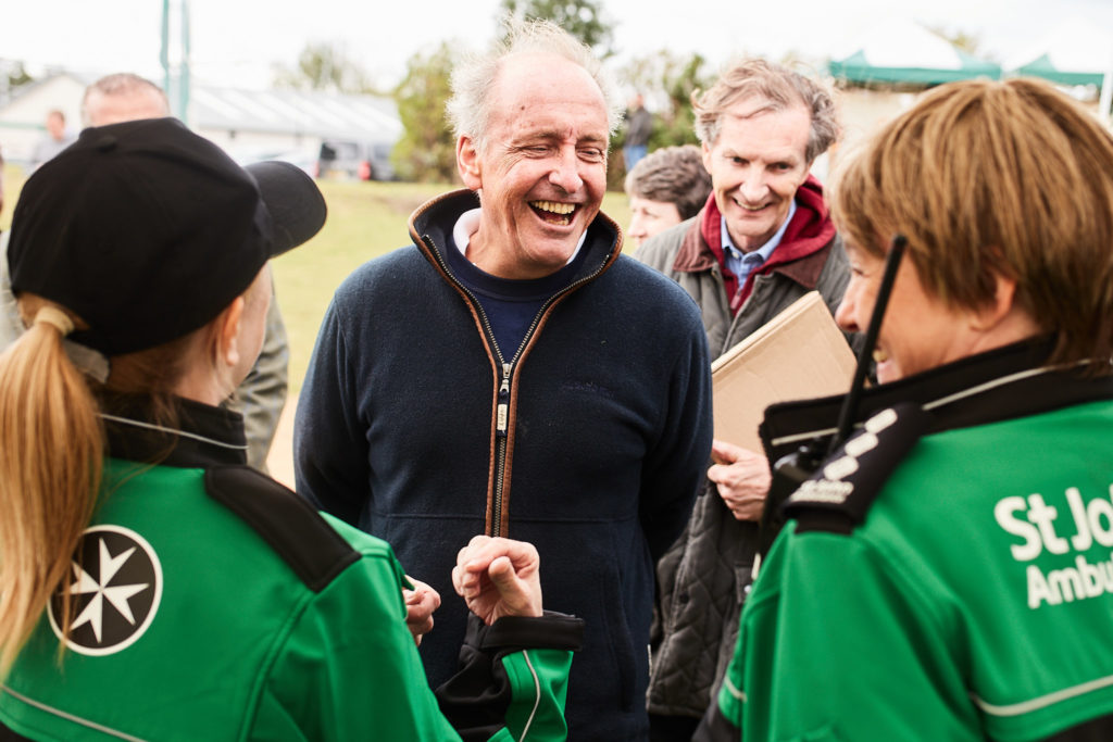 Man laughing with St John Ambulance volunteers