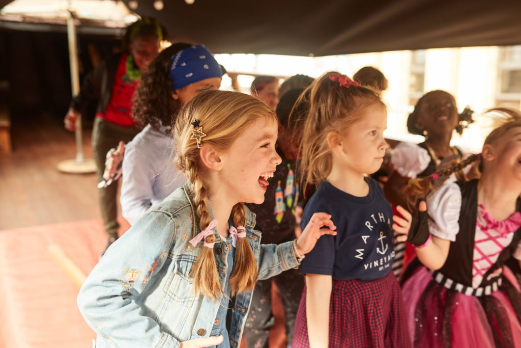 Children in pirate costumes laughing with the entertainer