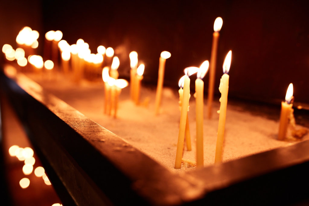 Candles burning in a sand tray inside a Serbian Orthodox church