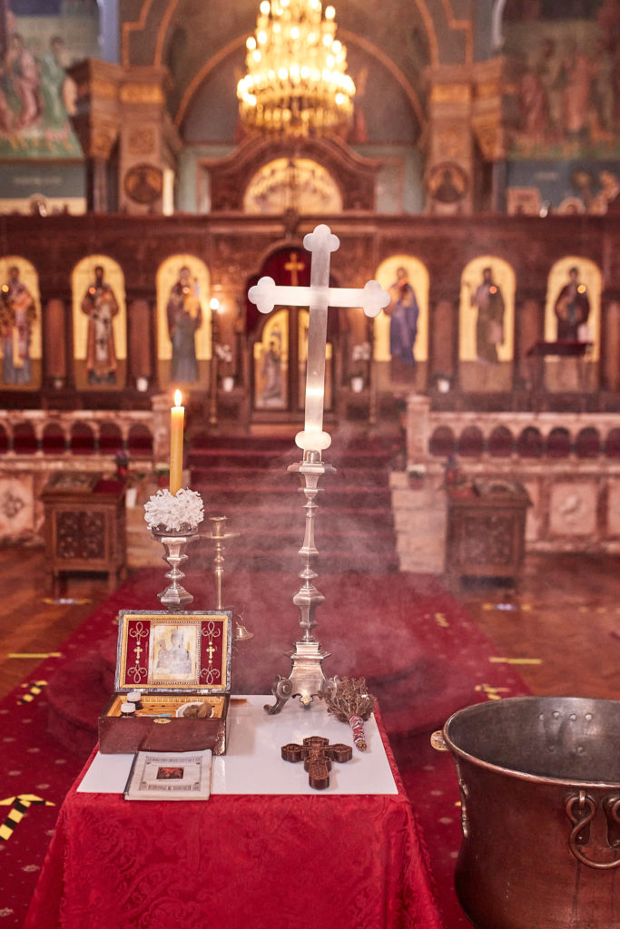 Baptism table and font set in front of the gilded icon screen