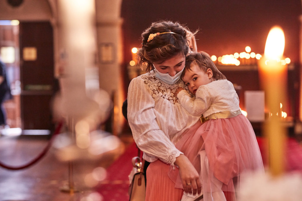 Mother cuddling her daughter in a pink tutu before her Orthodox baptism