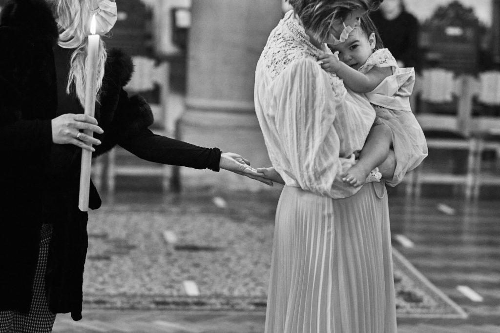 Black and white photo of a mother holding her daughter during the baptism service