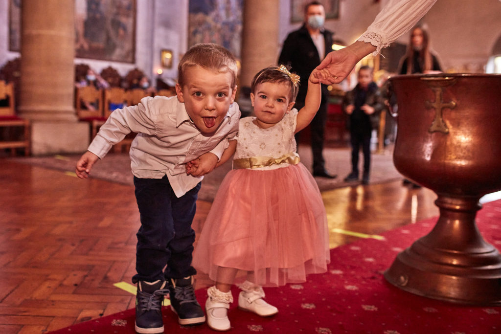 Boy pulling a funny face beside a toddler in a pink tutu