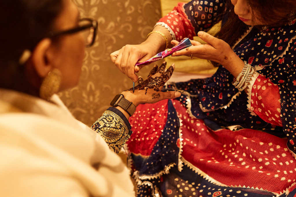 Close-up of henna being applied to a guest's hand