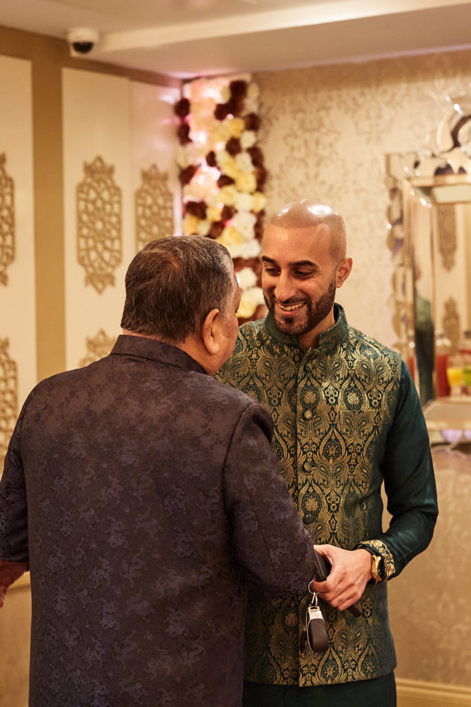 Groom-to-be in an embroidered waistcoat greeting a guest