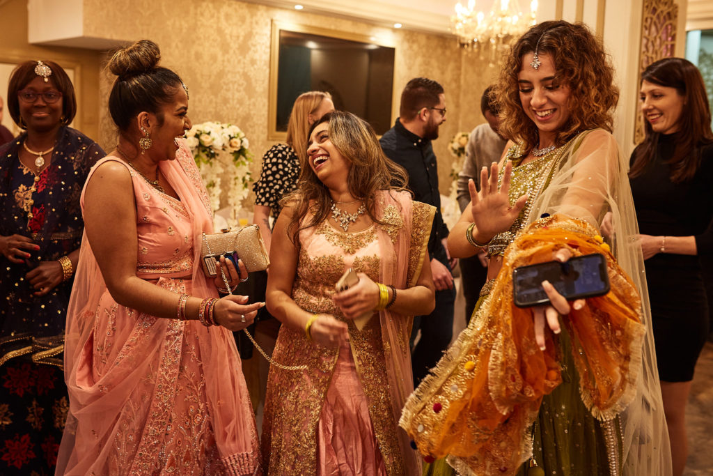 Guests in pastel lehengas laughing together