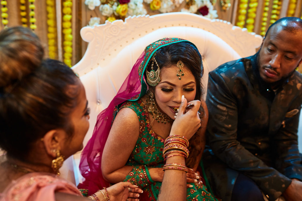 Bride laughing behind her hand as she sits beside the groom