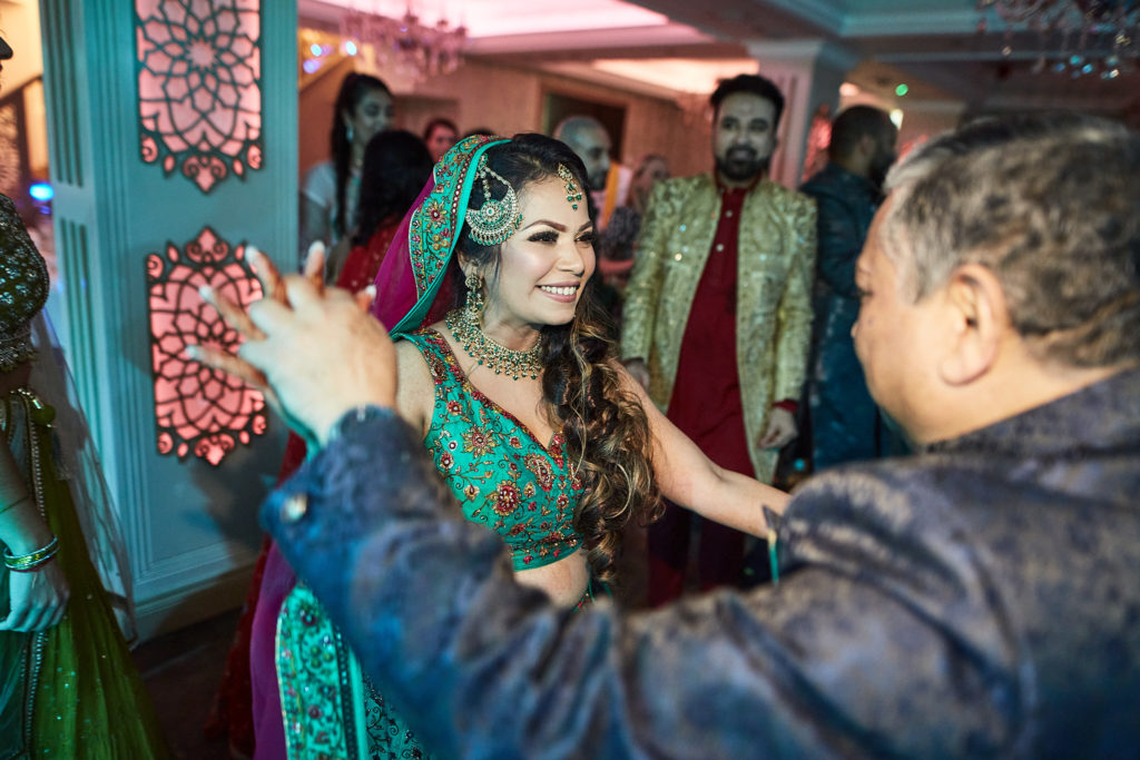 Guest filming the bride on his phone as she dances