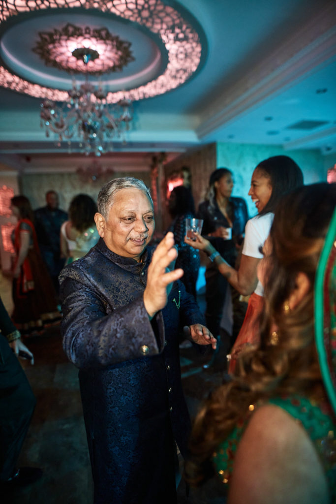 Older guest in a blue sherwani dancing