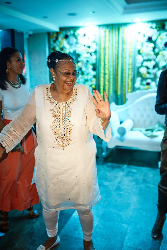 Older guest in a white embroidered outfit dancing