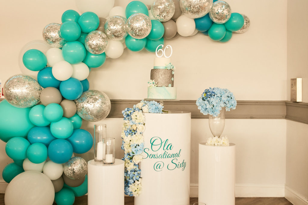 Turquoise, white and silver balloon display with a birthday welcome sign